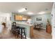 Eat-in kitchen with breakfast bar, wood cabinets, white appliances, and a dining area with a glass table and wrought iron chairs at 2136 Kerwood Loop, The Villages, FL 32162