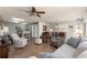 Open-concept living room with hardwood floors, comfortable seating, and a view of the dining area and kitchen at 2136 Kerwood Loop, The Villages, FL 32162