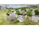 Overhead view features houses with screened patios, lush trees, a pond and a golf course at 2185 Caxton Ave, Clermont, FL 34711