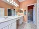 Bathroom with double vanity, decorative mirrors, and view of the walk-in shower at 2185 Caxton Ave, Clermont, FL 34711