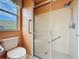 Bright bathroom featuring a glass-enclosed shower, safety bars, and a window with a neighborhood view at 2185 Caxton Ave, Clermont, FL 34711