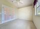 Bedroom with carpeted floors, ceiling fan and double doors that lead outside at 2185 Caxton Ave, Clermont, FL 34711
