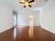 Light-filled primary bedroom with hardwood floors, ceiling fan, and view of the ensuite bath at 2185 Caxton Ave, Clermont, FL 34711