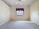 Spacious carpeted bedroom with ceiling fan, natural light and a window overlooking the neighborhood at 2185 Caxton Ave, Clermont, FL 34711