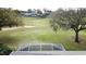 The pool cage offers a glimpse of the golf course and trees at 2185 Caxton Ave, Clermont, FL 34711