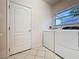 Functional laundry room with window, appliances, tile floors, and door at 2185 Caxton Ave, Clermont, FL 34711