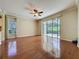 Spacious living room with hardwood floors, ceiling fan, and sliding glass doors to the lanai at 2185 Caxton Ave, Clermont, FL 34711