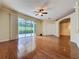 Spacious living room featuring hardwood floors, ceiling fan, and sliding glass doors to a patio at 2185 Caxton Ave, Clermont, FL 34711