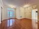 Open-concept living room with hardwood floors, decorative lighting, and a decorative glass front door at 2185 Caxton Ave, Clermont, FL 34711
