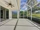Screened lanai boasts a ceiling fan, sliding glass doors, and views of the lush backyard at 2185 Caxton Ave, Clermont, FL 34711