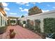 Beautiful backyard with a brick patio, pergola, lush greenery, and privacy wall create a relaxing outdoor space at 2212 Bachman Path, The Villages, FL 32162