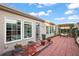 Back patio with brick pavers, ample seating, and access to the home's interior through sliding glass doors at 2212 Bachman Path, The Villages, FL 32162