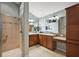 Elegant bathroom with a double vanity, granite countertops, tiled shower, and abundant storage at 2212 Bachman Path, The Villages, FL 32162