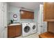 Well-organized laundry room featuring a washer, dryer, storage cabinets, sink, and neutral wall color at 2212 Bachman Path, The Villages, FL 32162