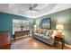 Cozy living room with a plush sofa, tray ceiling, wood flooring, and bright natural light at 2212 Bachman Path, The Villages, FL 32162