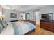 Comfortable main bedroom with hardwood floors, a view of connecting rooms, and a large dresser at 2212 Bachman Path, The Villages, FL 32162