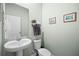 A clean half bathroom features a modern toilet and sink with a neutral colored wall paint and framed wall decor at 2289 Mystic Maze Ln, Minneola, FL 34715