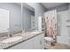 Well-lit bathroom featuring a double vanity with granite counters, a mirror, and a shower-tub combination at 2289 Mystic Maze Ln, Minneola, FL 34715