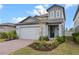 Stylish two-story home with a brick driveway and inviting front porch at 2289 Mystic Maze Ln, Minneola, FL 34715
