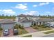 A home with a brick driveway and gray exterior showcases a well-manicured lawn and inviting curb appeal at 2289 Mystic Maze Ln, Minneola, FL 34715
