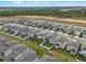 An aerial view captures a street with houses featuring well-maintained lawns and sidewalks at 2289 Mystic Maze Ln, Minneola, FL 34715