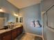 Bright bathroom featuring a double vanity, walk-in shower, and charming decorative accents at 2304 Jonesbury Run, The Villages, FL 32162