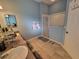 Well-lit bathroom with a tiled floor, shower, and vanity, complemented by stylish decorations at 2304 Jonesbury Run, The Villages, FL 32162