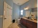 Bright bathroom with vanity and toilet and with the door visible in the mirror at 2304 Jonesbury Run, The Villages, FL 32162