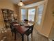 Cozy dining area featuring a dark wood table, black chairs, a wine rack, and plenty of natural light at 2304 Jonesbury Run, The Villages, FL 32162