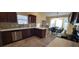 This kitchen includes dark wood cabinets and appliances, light countertops, and a cozy breakfast nook at 2304 Jonesbury Run, The Villages, FL 32162