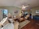 Inviting living room with comfortable sofas, ceiling fan, and wood flooring, perfect for relaxation and gatherings at 2304 Jonesbury Run, The Villages, FL 32162