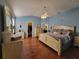 Spacious main bedroom with hardwood floors, a ceiling fan, and access to both the bathroom and closet at 2304 Jonesbury Run, The Villages, FL 32162