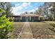 Charming home exterior with a pathway, large screened lanai and mature landscaping at 2541 Lake Griffin Rd, Lady Lake, FL 32159