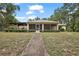 Charming single-story home with a screened-in porch and a well-maintained lawn and landscaping at 2541 Lake Griffin Rd, Lady Lake, FL 32159