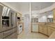 The kitchen showcases stainless steel refrigerator, white appliances, light cabinets, and tile flooring at 2541 Lake Griffin Rd, Lady Lake, FL 32159