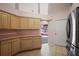 Kitchen featuring tile flooring, wood cabinetry, and stainless steel refrigerator at 2541 Lake Griffin Rd, Lady Lake, FL 32159