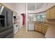 Kitchen featuring stainless steel refrigerator, wood cabinets, and tile flooring at 2541 Lake Griffin Rd, Lady Lake, FL 32159