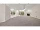 Expansive living room features neutral carpet, a fireplace, bright windows, and sliding glass doors to the lanai at 2541 Lake Griffin Rd, Lady Lake, FL 32159