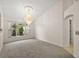 Carpeted living room with elegant chandelier and a large window that provides plenty of natural light at 2541 Lake Griffin Rd, Lady Lake, FL 32159