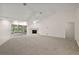 Expansive living room features neutral carpet, a fireplace, bright windows, and sliding glass doors to the lanai at 2541 Lake Griffin Rd, Lady Lake, FL 32159
