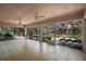 Large screened lanai with tile flooring, multiple ceiling fans, and scenic backyard views at 2541 Lake Griffin Rd, Lady Lake, FL 32159