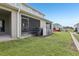 View of the backyard featuring the screen-enclosed patio and well-maintained lawn at 255 Blueberry Ln, Davenport, FL 33837