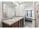 Bathroom featuring double sinks on a granite countertop vanity, matching mirror, and adjacent bedroom at 255 Blueberry Ln, Davenport, FL 33837