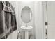 Bathroom features a pedestal sink, oval mirror and gray towels at 255 Blueberry Ln, Davenport, FL 33837