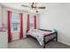 Cozy bedroom has a ceiling fan and pink curtains at 255 Blueberry Ln, Davenport, FL 33837