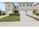 Modern two-story townhomes featuring attached garages, manicured landscaping, and concrete driveways at 255 Blueberry Ln, Davenport, FL 33837