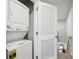 A stacked white washer and dryer behind a door at 255 Blueberry Ln, Davenport, FL 33837