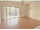 Bright living room with sliding glass doors to the balcony and wood flooring with neutral paint at 2562 Lakeway Branch Way # 3002, Orlando, FL 32839