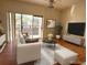 Living room with hardwood floors, white sofa, sliding glass doors to the balcony, and neutral paint at 2562 Lakeway Branch Way # 3002, Orlando, FL 32839