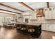 Modern kitchen boasts a large island, wooden beams, and stainless steel appliances adjacent to the dining area at 2600 Robie Ave, Mount Dora, FL 32757